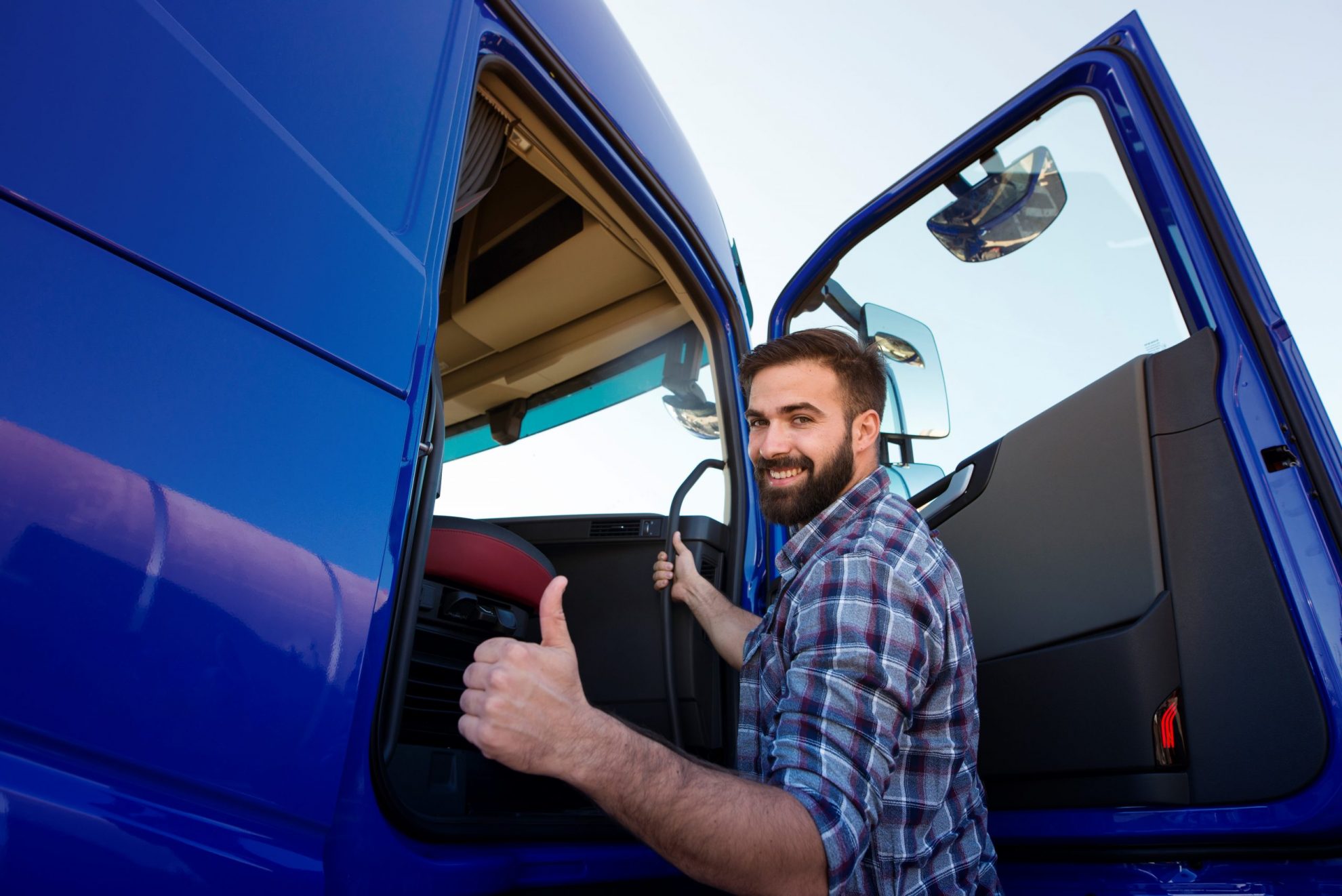 Photo of trucker giving thumbs up illustrates blog: A Quick Guide to Freight Factoring
