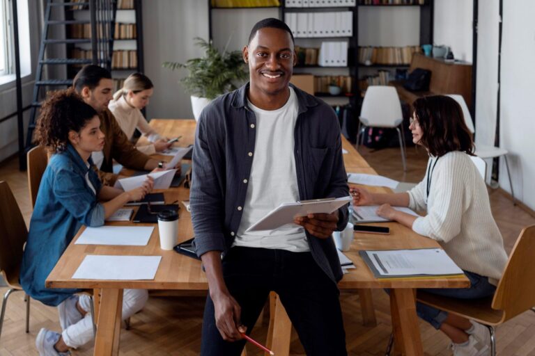 Smiling man in conference room illustrates blog "Invoice Factoring for Working Capital: Is It a Good Idea?"