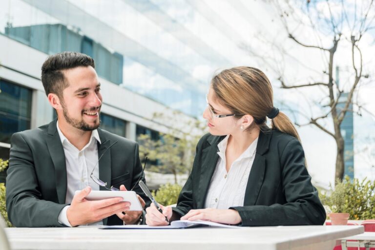 Man and woman in business attire illustrate blog " Invoice Factoring vs. Line of Credit: Which One is Better for Your Business?"