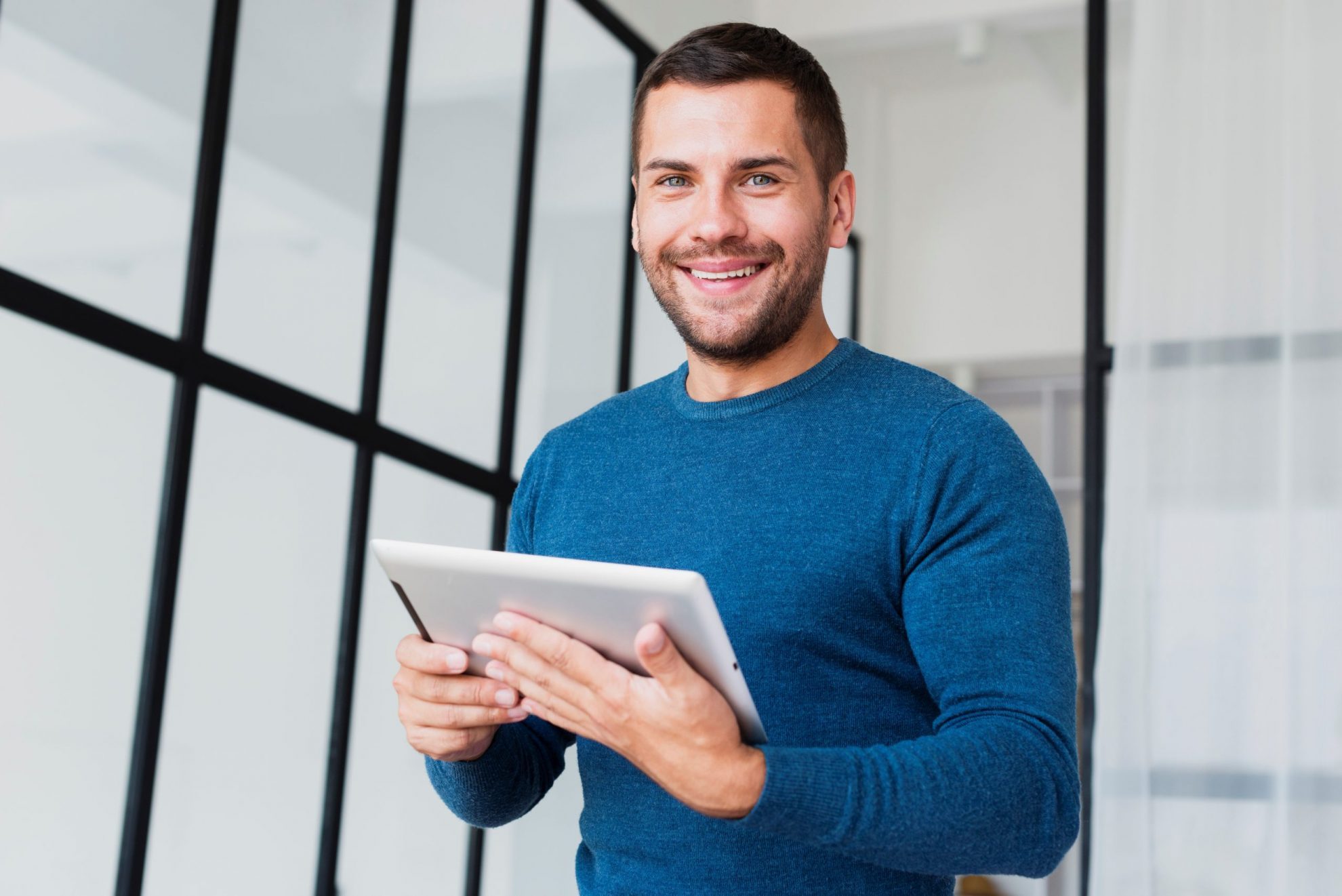 casual-businessman-FP Smiling man holding tablet illustrates blog "Receivables Factoring vs Asset-Based Lending: What Is the Difference?"