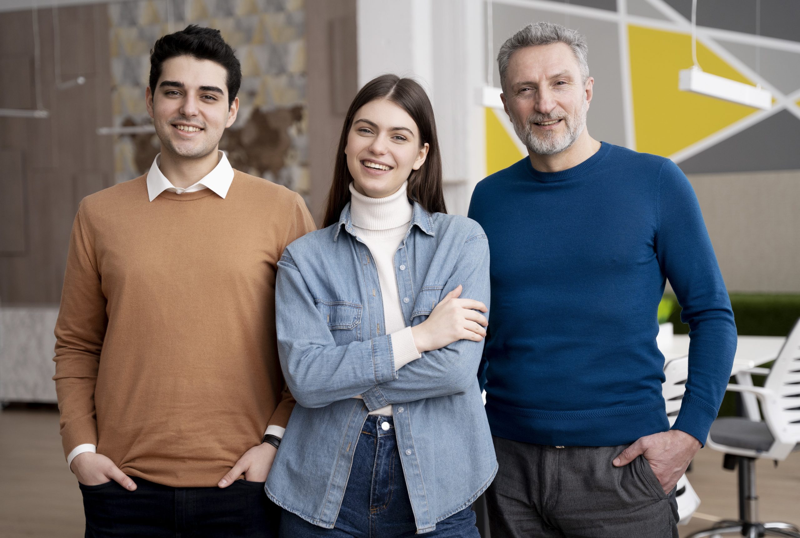 Two men and a woman smiling and dressed casually illustrate blog "What Is a Factoring Company? "