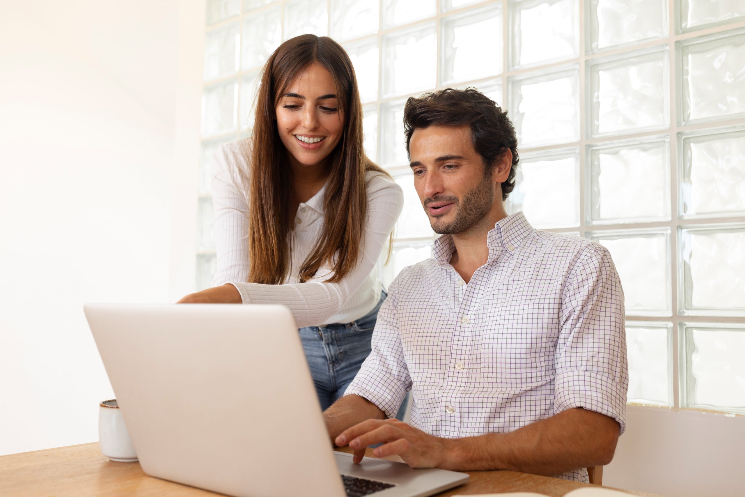 Man and woman looking at laptop illustrates blog "Are Cash Flow and EBITDA the Same?"