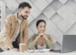 Man and woman looking at laptop illustrate blog "What Are the Benefits of Receivables Management?"