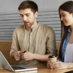 Two casual people in office illustrate blog "Factoring vs Assignment of Receivables: What is the Difference?"