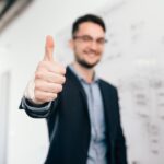 Man giving thumbs up illustrates blog "What Does 'Cash Flow-Positive' Mean?"
