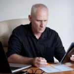 Business owner preparing for invoice factoring with organized invoices