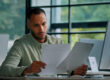 Business owner reviewing invoice factoring credit score impact on laptop