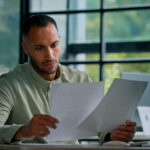Business owner reviewing invoice factoring credit score impact on laptop