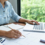 invoice factoring benefits business owner reviewing invoices for cash flow