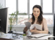 realistic small business owner reviewing invoices and cash flow documents with a financing advisor in an office