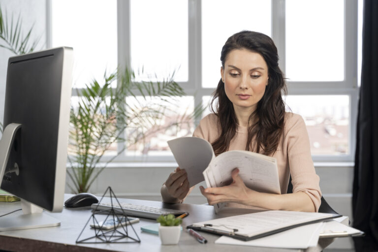 realistic small business owner reviewing invoices and cash flow documents with a financing advisor in an office