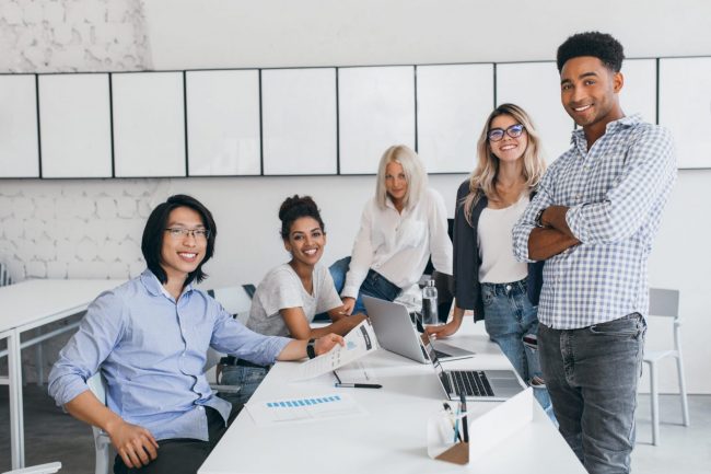 Team of five people in office illustrates blog: " Factoring Helps Companies in the Service Industry"