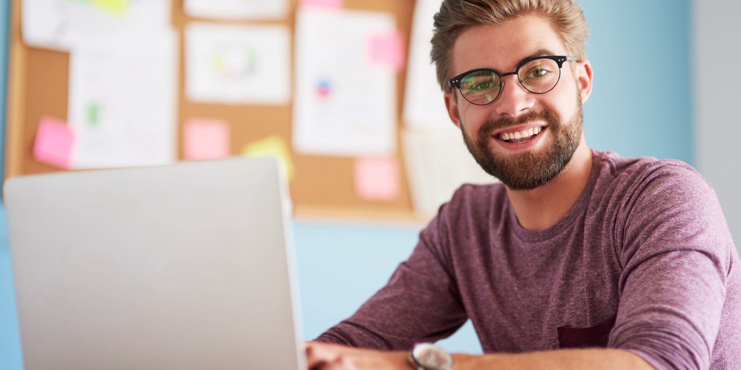 Photo of man looking at laptop illustrates blog: "Why Do Companies Factor Their Receivables?"