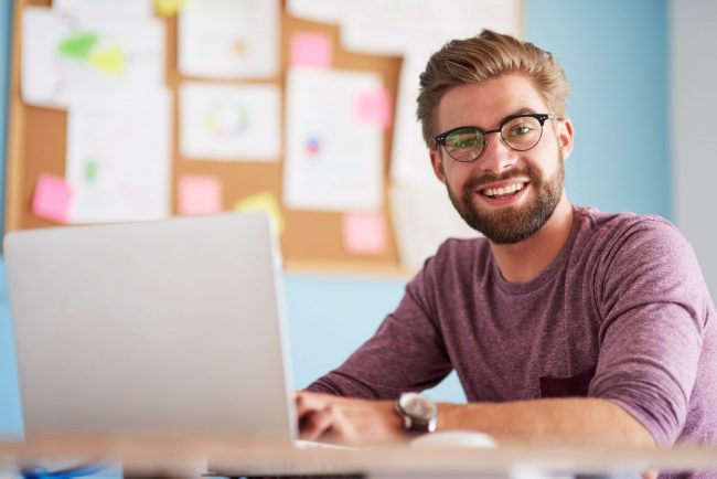 Photo of man looking at laptop illustrates blog: "Why Do Companies Factor Their Receivables?"