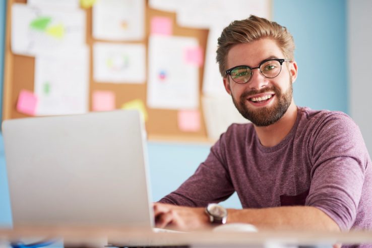 Photo of man looking at laptop illustrates blog: "Why Do Companies Factor Their Receivables?"