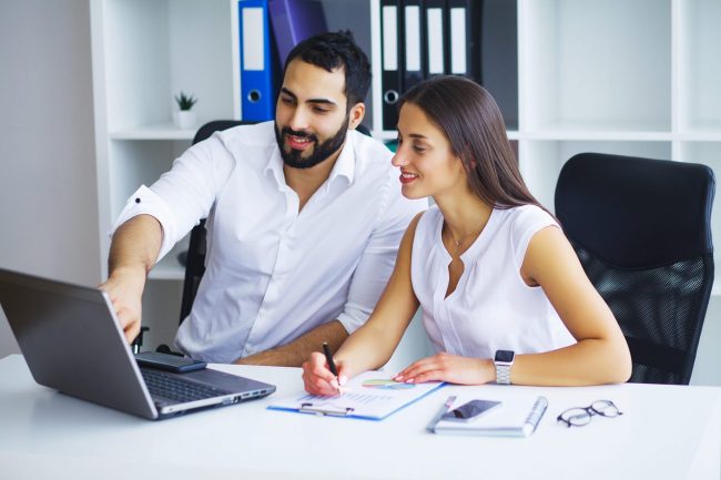 Man and woman looking at laptop illustrate blog "Are Accounts Receivable Assets or Liabilities?"
