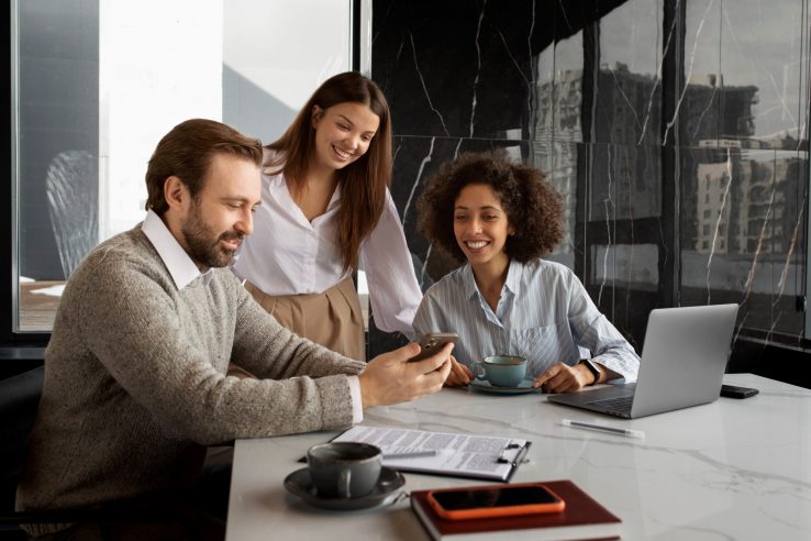 bad-debt-FP Office workers looking at smartphone illustrate blog "4 Tips To Avoid Bad Debt"