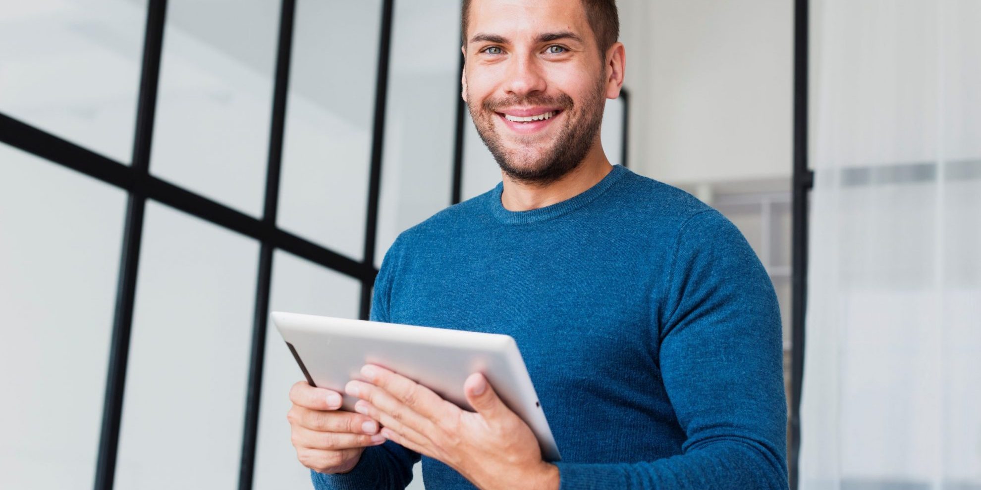 casual-businessman-FP Smiling man holding tablet illustrates blog "Receivables Factoring vs Asset-Based Lending: What Is the Difference?"