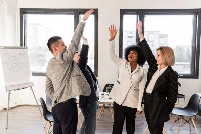 high-five-FP Group of four people high-fiving each other illustrates blog "4 Ways to Fund Business Growth"