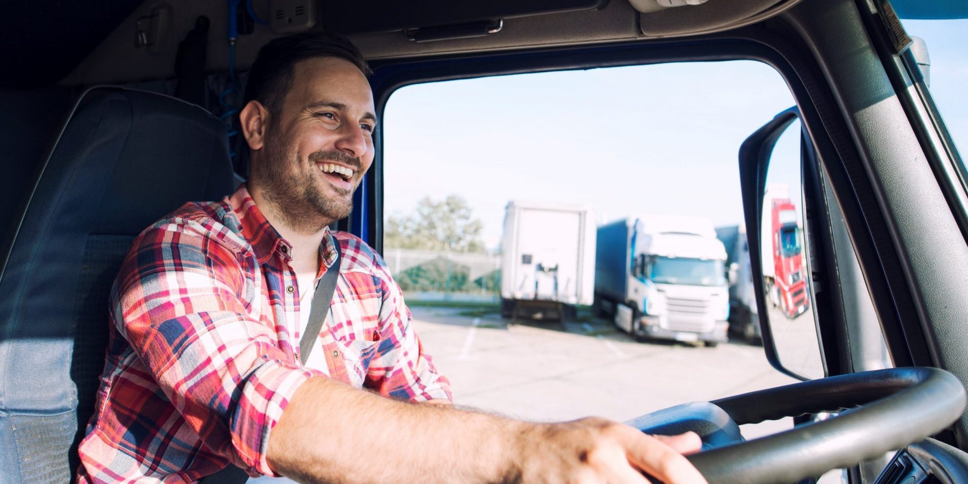 Closeup of trucker at the wheel illustrates blog "Is Factoring of Accounts Receivable a Good Idea for Trucking Companies?"
