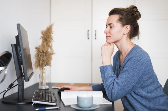 woman-office-fp Woman sitting at desk looking at computer illustrates blog "Do Factoring Companies Check Your Credit?"
